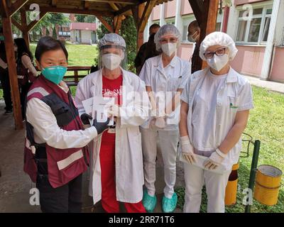 210308 -- GUANGZHOU, 8 marzo 2021 -- il membro del team medico cinese Cheng Shouzhen 1st L consegna opuscoli sulla prevenzione dell'epidemia di COVID-19 allo staff medico di un centro infermieristico di Belgrado, Serbia, 12 maggio 2020. Durante la pandemia di COVID-19 a Wuhan, Cheng Shouzhen ha guidato più di 130 membri del team del primo ospedale affiliato della Sun Yat-sen University per offrire assistenza medica. Dopo due mesi di lotta contro l'epidemia, i suoi capelli diventarono grigi. Dopo essere tornato da Wuhan e aver fatto un breve riposo, Cheng Shouzhen si unì alla squadra di esperti medici cinesi che assisteva la Serbia e continuava a combattere Foto Stock