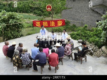 210308 -- PECHINO, 8 marzo 2021 -- i membri dello staff della Corte del popolo della contea di Yunyang pubblicizzano le conoscenze giuridiche tra gli abitanti del villaggio di Tuanpu nella contea di Yunyang nel sud-ovest della Cina, a Chongqing, 12 aprile 2018. Foto di /Xinhua Xinhua titoli: Uno sguardo alla democrazia cinese, stato di diritto in due sessioni RaoxGuojun PUBLICATIONxNOTxINxCHN Foto Stock