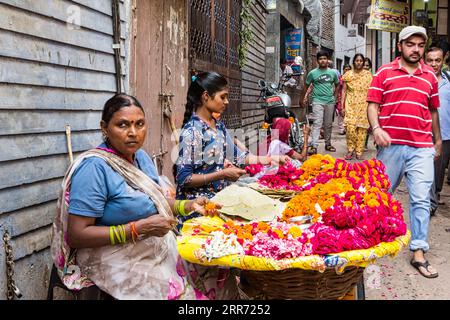 Vrindavan, Uttar Pradesh, 19 ottobre 2019: Fiorista indiana che vende i suoi prodotti floreali al mattino per le strade di Vrindavan Foto Stock