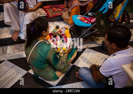 Vrindavan, Uttar Pradesh, 19 ottobre 2019: Una donna che tiene in grembo Lord Krishnaon, sentendosi proprio bambino al Sri Krishna-Balaram Mandir. E' un Foto Stock