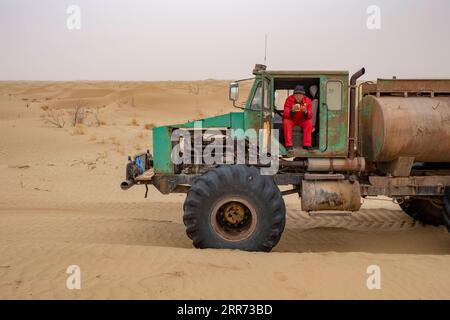 210310 --URUMQI, 10 marzo 2021 -- Un lavoratore del team di indagine geofisica pranza nel deserto di Taklimakan, regione autonoma di Xinjiang Uygur, nella Cina nordoccidentale, 25 febbraio 2021. Il deserto di Taklimakan, situato nel bacino del Tarim, nella regione autonoma di Xinjiang Uygur della Cina nord-occidentale, è una delle principali regioni petrolifere della Cina e una delle più difficili da esplorare a causa del suo ambiente duro e delle complicate condizioni sotterranee. Per esplorare le risorse di petrolio e gas sono necessari più processi, tra cui lo svolgimento di indagini geofisiche, in modo da raccogliere dati sismici per gettare solide basi f Foto Stock