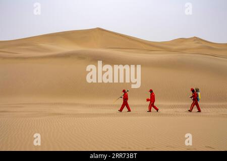 210310 --URUMQI, 10 marzo 2021 -- Feng Yongsheng L, Feng Shuangsheng C e Feng Zhipeng del team di indagine geofisica lavorano nel deserto di Taklimakan, regione autonoma Xinjiang Uygur della Cina nord-occidentale, 25 febbraio 2021. Il deserto di Taklimakan, situato nel bacino del Tarim, nella regione autonoma di Xinjiang Uygur della Cina nord-occidentale, è una delle principali regioni petrolifere della Cina e una delle più difficili da esplorare a causa del suo ambiente duro e delle complicate condizioni sotterranee. Per esplorare le risorse di petrolio e gas sono necessari più processi, tra cui lo svolgimento di indagini geofisiche, in modo da raccogliere Foto Stock