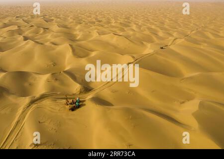 210310 --URUMQI, 10 marzo 2021 -- la foto aerea mostra i lavoratori del team geofisico che svolgono lavori di perforazione nel deserto di Taklimakan, regione autonoma di Xinjiang Uygur, nella Cina nord-occidentale, 24 febbraio 2021. Il deserto di Taklimakan, situato nel bacino del Tarim, nella regione autonoma di Xinjiang Uygur della Cina nord-occidentale, è una delle principali regioni petrolifere della Cina e una delle più difficili da esplorare a causa del suo ambiente duro e delle complicate condizioni sotterranee. Per esplorare le risorse di petrolio e gas sono necessari più processi, tra cui la conduzione di indagini geofisiche, in modo da raccogliere il seismo Foto Stock