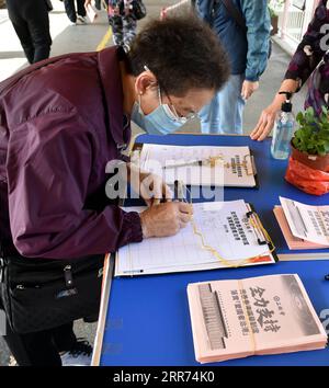 210312 -- HONG KONG, 12 marzo 2021 -- Un cittadino firma il suo nome durante una campagna a sostegno della decisione di migliorare il sistema elettorale della regione amministrativa speciale di Hong Kong da parte del Congresso Nazionale del popolo NPC a Hong Kong, Cina meridionale, 11 marzo 2021. La decisione è stata approvata da una maggioranza schiacciante nella quarta sessione del 13° NPC, la prima legislatura cinese, giovedì. CHINA-HONG KONG-NPC-DECISIONE SUL MIGLIORAMENTO DEL SOSTEGNO AL SISTEMA ELETTORALE CN LOXPINGXFAI PUBLICATIONXNOTXINXCHN Foto Stock