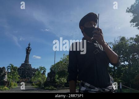 210314 -- BALI, 14 marzo 2021 -- Un funzionario della sicurezza sta di guardia in strada durante il giorno di Nyepi, o il giorno del silenzio, in mezzo all'epidemia di COVID-19 a Denpasar, Bali, Indonesia, 14 marzo 2021. Nyepi segna il capodanno del calendario balinese Saka in Indonesia. In questa festività pubblica, la gente del posto si dedica al digiuno e alla meditazione, astenendosi da pratiche come l'accensione di fuochi, il lavoro, i viaggi e l'intrattenimento. Foto di /Xinhua INDONESIA-BALI-COVID-19-NYEPI DAY Bisinglasi PUBLICATIONxNOTxINxCHN Foto Stock