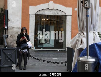 210316 -- ROMA, 16 marzo 2021 -- Una donna ha un gelato fuori da un ristorante chiuso a Roma, in Italia, 15 marzo 2021. Lunedì l'Italia è entrata in un nuovo periodo di semi-confinamento, con oltre la metà delle sue 20 regioni che rientrano nella zona rossa e soggette al livello massimo di restrizioni. ITALIA-ROMA-COVID-19-SEMI-LOCKDOWN ChengxTingting PUBLICATIONxNOTxINxCHN Foto Stock