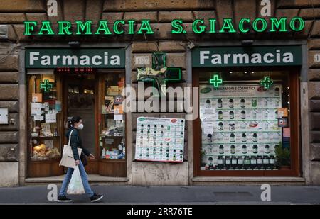 210316 -- ROMA, 16 marzo 2021 -- Una donna che indossa una maschera cammina davanti a una farmacia in via del corso a Roma, 15 marzo 2021. Lunedì l'Italia è entrata in un nuovo periodo di semi-confinamento, con oltre la metà delle sue 20 regioni che rientrano nella zona rossa e soggette al livello massimo di restrizioni. ITALIA-ROMA-COVID-19-SEMI-LOCKDOWN ChengxTingting PUBLICATIONxNOTxINxCHN Foto Stock