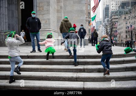 210317 -- NEW YORK, 17 marzo 2021 -- i bambini giocano davanti a St. Patrick, sulla Cattedrale di St Patrick S Day a New York, Stati Uniti, 17 marzo 2021. A causa della pandemia di COVID-19, l'annuale St. Patrick's Day Parade è andata per lo più virtuale a New York quest'anno. Foto di /Xinhua U.S.-NEW YORK-COVID-19-ST. GIORNO DI PATRICK MichaelxNagle PUBLICATIONxNOTxINxCHN Foto Stock