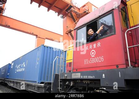 210319 -- CHONGQING, 19 marzo 2021 -- Un conducente segnala davanti a un treno merci Yuxin ou Chongqing-Xinjiang-Europe China-Europe lascia la stazione del villaggio di Tuanjie nel comune di Chongqing della Cina sud-occidentale, 19 marzo 2021. Con un forte fischio che riecheggia attraverso l'aria, un treno merci diretto a Duisburg, in Germania, è lentamente uscito dalla stazione del villaggio di Tuanjie nel comune di Chongqing della Cina sud-occidentale il venerdì mattina. Esattamente un decennio fa, ho segnalato al primo treno merci Cina-Europa, lo Yuxin ou Chongqing-Xinjiang-Europe, di partire da qui, ha ricordato Zhang Xin mentre vedeva Foto Stock