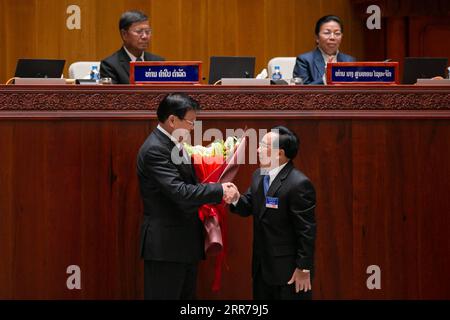 News Bilder des Tages 210322 -- VIENTIANE, 22 marzo 2021 -- il neoeletto primo ministro del Laos Phankham Viphavanh R, il fronte stringe la mano a Thongloun Sisoulith, appena eletto come nuovo presidente del paese, nella sessione inaugurale della nona legislatura dell'Assemblea nazionale del Laos a Vientiane, Laos, il 22 marzo 2021. La sessione inaugurale in corso della nona legislatura dell'Assemblea Nazionale del Laos NA lunedì mattina ha eletto Thongloun Sisoulith, segretario generale del Comitato centrale LPRP del Partito Rivoluzionario del popolo del Laos, come nuovo presidente del paese, sostituendo Bounnhang Foto Stock