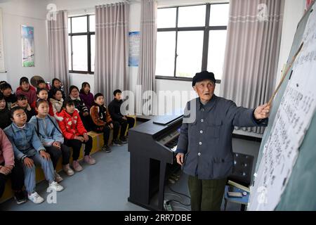 210326 -- HEFEI, 26 marzo 2021 -- Yan Mingyou insegna una canzone agli studenti della Zhuwan Primary School nella Zhuwan Township della contea di Dingyuan, Chuzhou City, East China S Anhui Province, 23 marzo 2021. Yan Mingyou, 92 anni, è ancora al posto di insegnare musica nelle scuole elementari rurali. Ritiratosi come insegnante rurale nel 1990, Yan si è offerto volontario per insegnare musica agli studenti delle scuole rurali. Nel 1953, Yan lasciò l'esercito e tornò nella sua città natale Zhuwan Township nella contea di Dingyuan. Rinunciò a un lavoro migliore presso il governo locale e scelse di lavorare nelle scuole rurali, insegnando varie materie come po Foto Stock