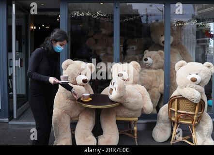 210326 -- PARIGI, 26 marzo 2021 -- il proprietario del caffè Bouquet Wagram, che fornisce servizi da asporto, serve caffè per orsacchiotti giganti a Parigi, in Francia, 26 marzo 2021. Giovedì il ministro francese della sanità Olivier Veran ha annunciato misure di frenata rafforzate in altre tre regioni ad alto rischio COVID-19 - Rhone, Aube e Nievre - nel tentativo di contenere una terza ondata della pandemia. FRANCE-PARIS-GIANT TEDDY BEARS GaoxJing PUBLICATIONxNOTxINxCHN Foto Stock