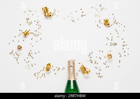 Bottiglia di champagne vista dall'alto con coriandoli di nastri dorati Foto Stock