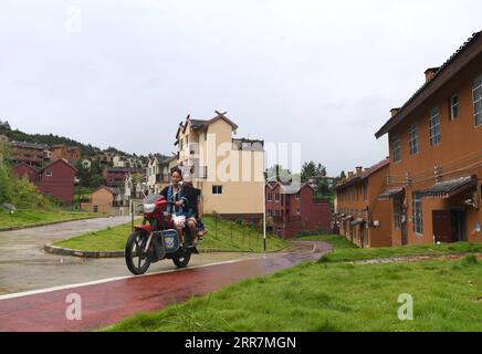 210331 -- NANNING, 31 marzo 2021 -- gli abitanti del villaggio cavalcano una moto sulla strada di un'area di reinsediamento nella contea di Nandan, nella regione autonoma del Guangxi Zhuang, nella Cina meridionale, il 6 agosto 2020. Dal 2016, il Guangxi ha promosso la costruzione e il miglioramento della rete stradale rurale, con 52 900 chilometri di strade costruite per collegare i villaggi nelle aree rurali. CHINA-GUANGXI-ROAD-CONSTRUCTION CN ZhouxHua PUBLICATIONxNOTxINxCHN Foto Stock