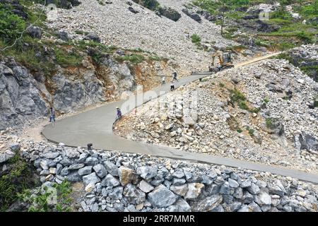 210331 -- NANNING, 31 marzo 2021 -- foto aerea scattata il 13 maggio 2020 mostra persone che costruiscono la strada di accesso a Nonggentun del villaggio di Nonghe nella contea autonoma di Dahua Yao, nella regione autonoma del Guangxi Zhuang nella Cina meridionale. Dal 2016, il Guangxi ha promosso la costruzione e il miglioramento della rete stradale rurale, con 52 900 chilometri di strade costruite per collegare i villaggi nelle aree rurali. CHINA-GUANGXI-ROAD-CONSTRUCTION CN ZhouxHua PUBLICATIONxNOTxINxCHN Foto Stock