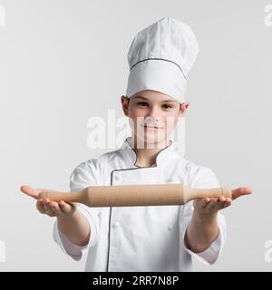 Ritratto giovane maestro chef che tiene in mano il mattarello Foto Stock