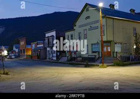 Atmosfera serale nella città della corsa all'oro di Dawson City, case in legno in stile occidentale, passerelle, Yukon, Canada Foto Stock