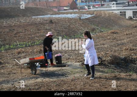 210407 -- SHENYANG, 7 aprile 2021 -- Sun Yi saluta un abitante del villaggio mentre si dirige verso la casa di un paziente nel villaggio di Qianyang, Donggang City, provincia di Liaoning della Cina nord-orientale, 6 aprile 2021. Sun Yi, nato nel 1997, lavora come medico di villaggio nel villaggio di Qianyang. Dopo essersi laureata in medicina clinica, ha deciso di tornare nella sua città natale e salvaguardare la salute della gente del posto. Il villaggio di Qianyang ha una popolazione di oltre 14.000, dove un gran numero di persone soffre di pressione alta e diabete. Alcuni abitanti del villaggio sono lasciati indietro dai loro figli che lavorano come lavoratori migranti io Foto Stock