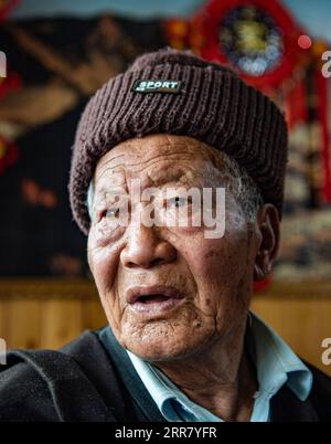 210409 -- LHASA, 9 aprile 2021 -- Ngawang Nyima posa per un ritratto nella sua residenza nella città di Qamdo, regione Autonoma Tibet della Cina sud-occidentale, 18 febbraio 2021. Ngawang Nyima, 84 anni, è nato a Naixi Township, nella contea di Mangkam, nella città di Qamdo, nella regione autonoma del Tibet sud-occidentale della Cina, ed era un servitore. Carico di pesanti tasse, iniziò a allevare pecore per proprietari terrieri quando non aveva più di otto anni, e fu costretto a prendere il bittern da una salina presso il fiume Lancang. Il sentiero verso la salina era così precipitoso che un singolo passo sconsiderato ne avrebbe fatto cadere uno in rapide onde nel fiume. Ngawang N. Foto Stock