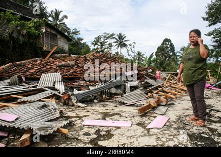 210411 -- GIAVA ORIENTALE, 11 aprile 2021 -- Una donna è vista vicino a case danneggiate dopo che un terremoto di magnitudo 6,1 ha colpito il villaggio di Kali Uling a Lumajang, Giava Orientale, Indonesia, 11 aprile 2021. Sei persone sono state uccise, un'altra è stata gravemente ferita e decine di edifici sono stati danneggiati dopo che un terremoto di magnitudo 6,1 ha scosso la provincia occidentale indonesiana di Giava orientale sabato, hanno detto i funzionari. Il terremoto colpì alle 14:00, ora di Giacarta 0700 GMT, con l'epicentro 96 km a sud della città di Kepanjen, nel distretto di Malang, con una profondità di 80 km, Andry Sembiring, un funzionario della Meteorologia, Climatologia e Geofisica Foto Stock