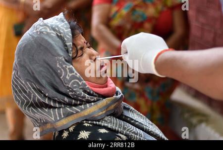 210411 -- PRAYAGRAJ INDIA, 11 aprile 2021 -- Un operatore sanitario raccoglie un tampone da una donna a Prayagraj, nello stato settentrionale dell'India dell'Uttar Pradesh, l'11 aprile 2021. L'India ha riportato un record di 152.879 nuovi casi di COVID-19 domenica, portando il totale a 13.358.805, secondo i dati rilasciati dal governo federale. Str/Xinhua INDIA-PRAYAGRAJ-COVID-19-TEST JavedxDar PUBLICATIONxNOTxINxCHN Foto Stock