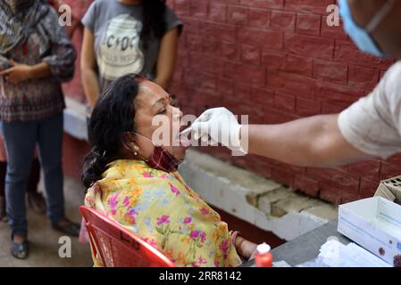 210411 -- PRAYAGRAJ INDIA, 11 aprile 2021 -- Un operatore sanitario raccoglie un tampone da una donna a Prayagraj, nello stato settentrionale dell'India dell'Uttar Pradesh, l'11 aprile 2021. L'India ha riportato un record di 152.879 nuovi casi di COVID-19 domenica, portando il totale a 13.358.805, secondo i dati rilasciati dal governo federale. Str/Xinhua INDIA-PRAYAGRAJ-COVID-19-TEST JavedxDar PUBLICATIONxNOTxINxCHN Foto Stock