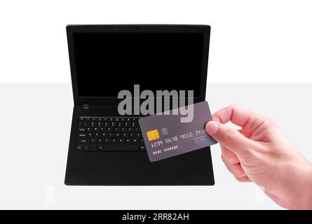 Carta di credito e privilegi finanziari per lo shopping online e il pagamento, carta di credito nera con maniglia, schermo vuoto per computer portatile Foto Stock