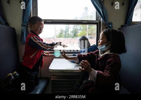 210415 -- XICHANG, 15 aprile 2021 -- i bambini prendono il treno 5633 per andare a scuola nella provincia del Sichuan della Cina sud-occidentale, 11 aprile 2021. Mentre i moderni treni ad alta velocità passano accanto a nuove stazioni in tutta la Cina, un paio di treni a bassa velocità continuano a circolare attraverso i Monti Daliang. I 5633/5634 treni corrono tra Puxiong e Panzhihua della provincia del Sichuan con una velocità media inferiore a 40 km/h. Il viaggio con 26 stazioni in un intervallo di undici ore e quattro minuti, con i prezzi dei biglietti che vanno da 2 yuan a 25,5 yuancirca 0,3-3,9 dollari USA. I treni a bassa velocità mandano i bambini a scuola Foto Stock