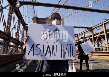 210417 -- WASHINGTON, 17 aprile 2021 -- la gente marcia per protestare contro i crimini anti-asiatici di odio sul ponte di Brooklyn a New York, negli Stati Uniti, 4 aprile 2021. Xinhua titoli: Gli Stati Uniti hanno molta strada da fare per reprimere i crimini di odio anti-asiatici WangxYing PUBLICATIONxNOTxINxCHN Foto Stock