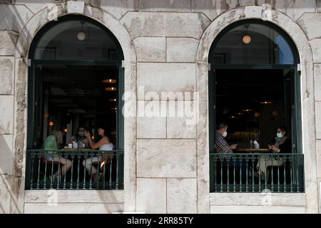 210420 -- LISBONA, 20 aprile 2021 -- la gente pranza in un ristorante a Lisbona, in Portogallo, il 19 aprile 2021. Lunedì il Portogallo ha proceduto alla terza fase del deconfinamento o dell’allentamento delle misure di confinamento della COVID-19, con la graduale riapertura dei servizi e di altre attività nei comuni con un tasso di incidenza della COVID-19 relativamente basso. Nella maggior parte del paese, le scuole hanno ripreso l'educazione di persona e i negozi, i centri commerciali e i ristoranti hanno riaperto con restrizioni di occupazione e misure di salute e sicurezza nei negozi. Foto di /Xinhua PORTUGAL-LISBON-COVID-19-3A FASE DI SBLOCCO PedroxFiuza PU Foto Stock