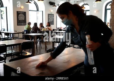 210420 -- LISBONA, 20 aprile 2021 -- la gente pranza in un ristorante a Lisbona, in Portogallo, il 19 aprile 2021. Lunedì il Portogallo ha proceduto alla terza fase del deconfinamento o dell’allentamento delle misure di confinamento della COVID-19, con la graduale riapertura dei servizi e di altre attività nei comuni con un tasso di incidenza della COVID-19 relativamente basso. Nella maggior parte del paese, le scuole hanno ripreso l'educazione di persona e i negozi, i centri commerciali e i ristoranti hanno riaperto con restrizioni di occupazione e misure di salute e sicurezza nei negozi. Foto di /Xinhua PORTUGAL-LISBON-COVID-19-3A FASE DI SBLOCCO PedroxFiuza PU Foto Stock