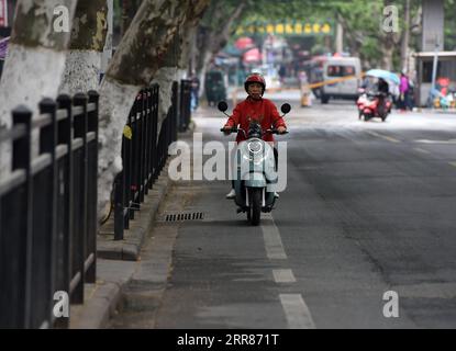 210422 -- HEFEI, 22 aprile 2021 -- Chen Guixia cavalca uno scooter sulla strada per la libreria Zengzhi a Hefei, nella provincia di Anhui della Cina orientale, 20 aprile 2021. Sin dalla sua apertura, 21 anni fa, la Zengzhi Bookshop, un rivenditore di libri di seconda mano non descritto nel centro di Hefei, è stata salutata come un punto di riferimento intellettuale tra gli appassionati di libri locali. Il suo defunto proprietario, Zhu Chuanguo, vantava una collezione di 000 libri usati, tutti acquistati da lettori ordinari e centri di riciclaggio. Secondo la visione di Zhu, i libri di scarto possono rivelarsi illuminanti per qualcun altro che merita quindi un lettore... Foto Stock