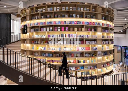 210423 -- HARBIN, 23 aprile 2021 -- Yu Bing porta libri alla M.I. Bookstore di Harbin, provincia di Heilongjiang, Cina nordorientale, 22 aprile 2021. Per Yu Bing, responsabile delle librerie con sede ad Harbin, il problema principale è sempre stato come creare un ambiente di lettura incoraggiante. Nato e cresciuto a Harbin, Yu è ora un veterano con 10 anni di esperienza nel settore della vendita di libri. Yu dice che il valore più grande della sua professione è la creazione di una piattaforma efficace per la condivisione di buoni libri -- come creare un layout allettante che attrae potenziali clienti e come scegliere tra una miriade di libri e. Foto Stock