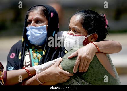 210426 -- NEW DELHI, 26 aprile 2021 -- i parenti di una vittima di COVID-19 si confondono a vicenda mentre raggiungono per raccogliere il corpo fuori dalla mortuaria dell'ospedale civile di Ahmedabad, India, 21 aprile 2021. PER ANDARE CON I TITOLI DI XINHUA DEL 26 APRILE 2021 STR/XINHUA INDIA-COVID-19-RISVEGLIO-SISTEMA SANITARIO STRINGER PUBLICATIONXNOTXINXCHN Foto Stock