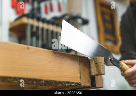 Utilizzo di morsa da banco per il taglio del legno con una sega a mano . Foto di alta qualità Foto Stock