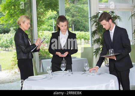 la cameriera senior e il suo team hanno preparato i tavoli Foto Stock