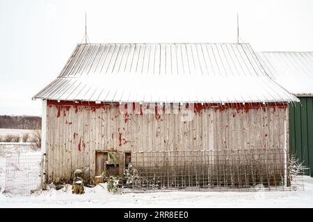 Un fienile d'epoca si trova in una tranquilla scena invernale Foto Stock