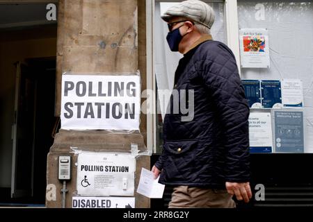 210507 -- LONDRA, 7 maggio 2021 -- Un uomo che indossa una maschera cammina fino a un'area elettorale di Charing Cross Road a Londra, in Gran Bretagna, il 6 maggio 2021. Milioni di elettori in Gran Bretagna si recheranno ai seggi elettorali per le elezioni locali in quello che i commentatori politici hanno definito il Super Thursday, che è visto come un test importante per i principali leader dei partiti politici britannici. Più di 5.000 seggi sono in palio nelle elezioni del municipio e del municipio, con il sindaco di Londra e 12 sindaci provinciali insieme a commissari della polizia e del crimine. Foto di /Xinhua BRITAIN-LONDON-LOCAL ELECTIONS da Foto Stock