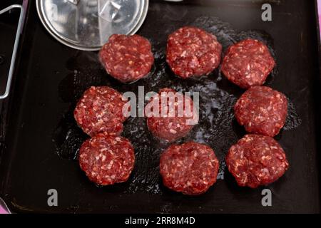 La carne macinata di manzo cucinata sullo spiedo per preparare gli hamburger. Foto Stock