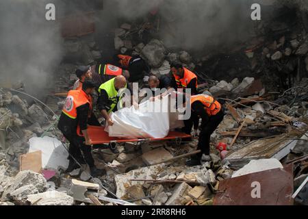 210516 -- GAZA, 16 maggio 2021 -- i membri della difesa civile palestinese salvano un uomo intrappolato sotto le macerie di case distrutte a seguito di attacchi aerei israeliani in al-Wahda Street nel centro di Gaza, il 16 maggio 2021. La tensione tra Israele e i gruppi militanti nella Striscia di Gaza è proseguita domenica per il settimo giorno di fila, mentre il bilancio delle vittime nell'enclave costiera è salito a 181 e altri 1.225 sono rimasti feriti, hanno detto i funzionari. Il ministero della salute a Gaza ha dichiarato in una dichiarazione stampa che da lunedì sono stati uccisi 181 palestinesi, tra cui 52 bambini e 31 donne, e altri 1.225 ha Foto Stock