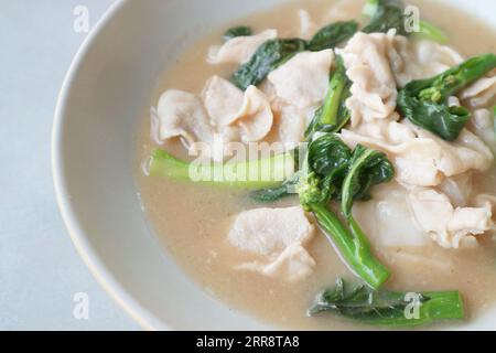 Primo piano di tagliatelle di riso in stile cinese con maiale fritto e cavolo in salsa con sugo di carne Foto Stock