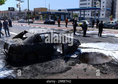 210518 -- GAZA/GERUSALEMME, 18 maggio 2021 -- Un'auto bruciata viene vista dopo che un razzo proveniente dalla Striscia di Gaza è atterrato nella città israeliana meridionale di Ashkelon, l'11 maggio 2021. /JINI via Xinhua Xinhua titoli: Con l'intensificarsi del conflitto tra Palestina e Israele, sono necessari coraggio e coscienza per raggiungere la pace TomerxNeuberg PUBLICATIONxNOTxINxCHN Foto Stock