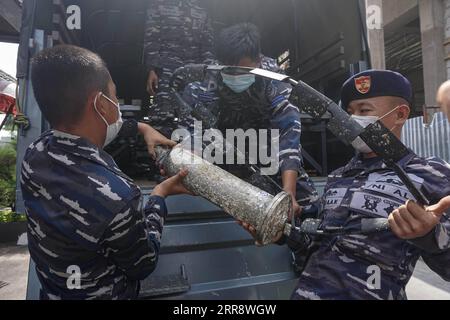 210519 -- DENPASAR, 19 maggio 2021 -- ufficiali della Marina indonesiana trasportano parti del sottomarino sommerso della Marina indonesiana KRI Nanggala-402 dopo una conferenza stampa a Denpasar, Bali, Indonesia, 18 maggio 2021. La Marina indonesiana, con l'assistenza della Marina dell'Esercito Popolare di Liberazione cinese, è riuscita a sollevare una zattera di salvataggio e altri frammenti appartenenti al sottomarino indonesiano affondato KRI Nanggala-402 nelle acque di Bali. Foto di /Xinhua INDONESIA-DENPASAR-SOMMERGIBILE-SOMMERGIBILE-SALVATAGGIO-CONFERENZA STAMPA Bisinglasi PUBLICATIONxNOTxINxCHN Foto Stock