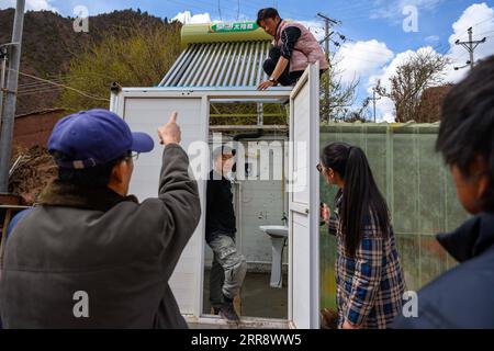 210519 -- PECHINO, 19 maggio 2021 -- li Chunmin 1st L lavora per aiutare a installare scaldabagno solari per gli abitanti locali nel villaggio di Pengda, Pengda Township, Riwoqe County of Qamdo, regione autonoma Tibet della Cina sud-occidentale, 2 maggio 2021. Nel China Photo Archive di Xinhua, c'è una foto di un ordine di denaro scattato da un reporter Xinhua 20 anni fa - la prima rimessa ricevuta dal quartier generale della costruzione ferroviaria Qinghai-Tibet. L'ordine di denaro non è stato firmato in quanto il remitter ha inviato Cadre solo per sostenere il Tibet nel 1979. Vent'anni dopo, i giornalisti di Xinhua trovarono li Chunmin, il proprietario dell'ormone Foto Stock