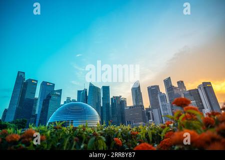 Singapore, 14 agosto 2023; negozio di Apple galleggiante nel quartiere centrale degli affari con cielo al tramonto e fiori in primo piano, cupola del negozio di Apple Foto Stock