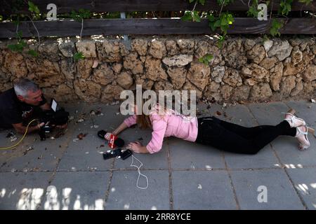 210520 -- ASHKELON ISRAEL, 20 maggio 2021 -- la gente prende copertura come una sirena di avvertimento di razzi in arrivo sparati dai suoni della Striscia di Gaza ad Ashkelon, nel sud di Israele, il 20 maggio 2021. Sia Israele che Hamas, che governa la Striscia di Gaza, hanno accettato un accordo di mediazione egiziana per cessare i combattimenti alle 2 del mattino di venerdì, ora locale, 2300 GMT giovedì per porre fine allo spargimento di sangue di 11 giorni. I combattimenti più pesanti tra Israele e militanti di Gaza dal 2014 hanno finora ucciso 232 palestinesi, tra cui 65 bambini e 39 donne, e 12 israeliani. Tramite Xinhua ISRAEL-ASHKELON-ROCKET-ATTACK IlanxAssayag/JINI PUBLICATIONxNOTxINxC Foto Stock