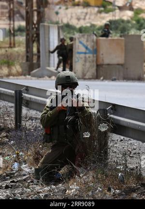 210521 -- NABLUS, 21 maggio 2021 -- un soldato israeliano prende posizione durante una protesta a sostegno dei palestinesi a Gerusalemme e nella Striscia di Gaza, in un posto di blocco vicino alla città di Nablus in Cisgiordania, il 21 maggio 2021. Foto di /Xinhua MIDEAST-NABLUS-CLASHES NidalxEshtayeh PUBLICATIONxNOTxINxCHN Foto Stock