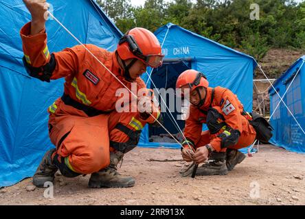 210522 -- YANGBI, 22 maggio 2021 -- i soccorritori ancorano il rifugio nel villaggio di Xiuling della contea autonoma di Yangbi Yi, provincia dello Yunnan della Cina sud-occidentale, 22 maggio 2021. Quattro terremoti di magnitudo superiore a 5,0 hanno colpito la contea autonoma di Yangbi Yi nella prefettura autonoma di Dali Bai dello Yunnan dalle 21:00 alle 23:00, venerdì, ora di Pechino. Le scosse si sono sentite in tutte le 12 contee e città della prefettura, con Yangbi che è stata la più colpita. Finora, oltre 16.200 soccorritori e materiali di soccorso, comprese tende e necessità quotidiane, sono stati inviati nell'area del terremoto. Oltre 22 milioni di yuan circa 3,4 milioni di dollari USA dol Foto Stock