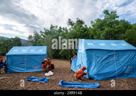 210522 -- YANGBI, 22 maggio 2021 -- i soccorritori costruiscono rifugi nel villaggio di Xiuling della contea autonoma di Yangbi Yi, provincia dello Yunnan della Cina sud-occidentale, 22 maggio 2021. Quattro terremoti di magnitudo superiore a 5,0 hanno colpito la contea autonoma di Yangbi Yi nella prefettura autonoma di Dali Bai dello Yunnan dalle 21:00 alle 23:00, venerdì, ora di Pechino. Le scosse si sono sentite in tutte le 12 contee e città della prefettura, con Yangbi che è stata la più colpita. Finora, oltre 16.200 soccorritori e materiali di soccorso, comprese tende e necessità quotidiane, sono stati inviati nell'area del terremoto. Oltre 22 milioni di yuan circa 3,4 milioni di dollari Foto Stock