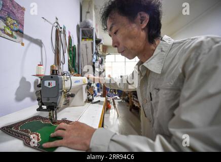 210527 -- XILINHOT, 27 maggio 2021 -- Xilinhu realizza un artigianato a forma di sella nel suo laboratorio a Xilinhot, nella regione autonoma della Mongolia interna della Cina settentrionale, 26 maggio 2021. Equitazione, tiro con l'arco e lotta sono chiamate le tre abilità degli uomini del gruppo etnico mongolo. Dal 2005, l'artigiano Xilinhu del gruppo etnico mongolo ha coinvolto i simboli culturali di sella, arco e freccia e costume da wrestling nell'artigianato per promuovere la cultura tradizionale del gruppo etnico. CINA-INTERNA MONGOLIA-XILINHOT-ARTIGIANATO CN PENGXYUAN PUBLICATIONXNOTXINXCHN Foto Stock